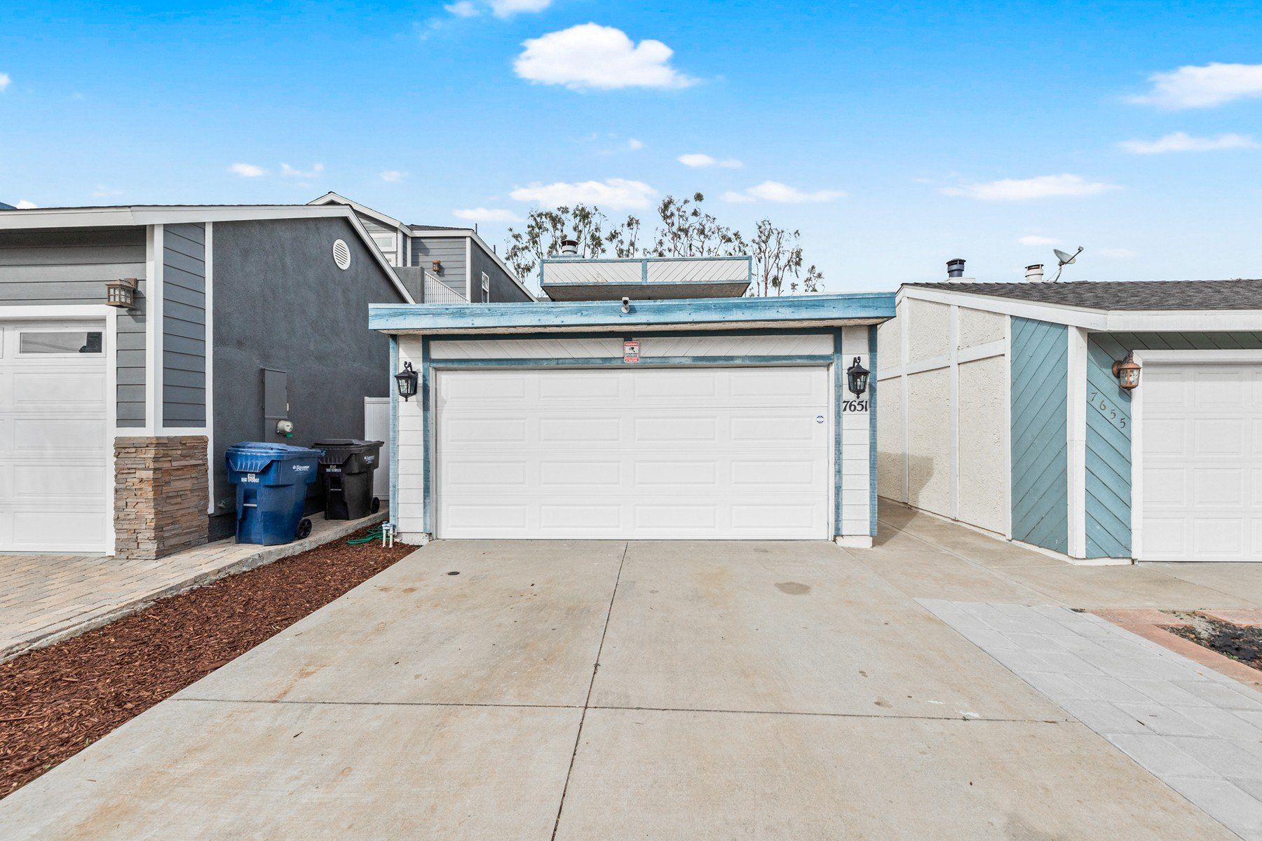 a white garage door is open in front of a house