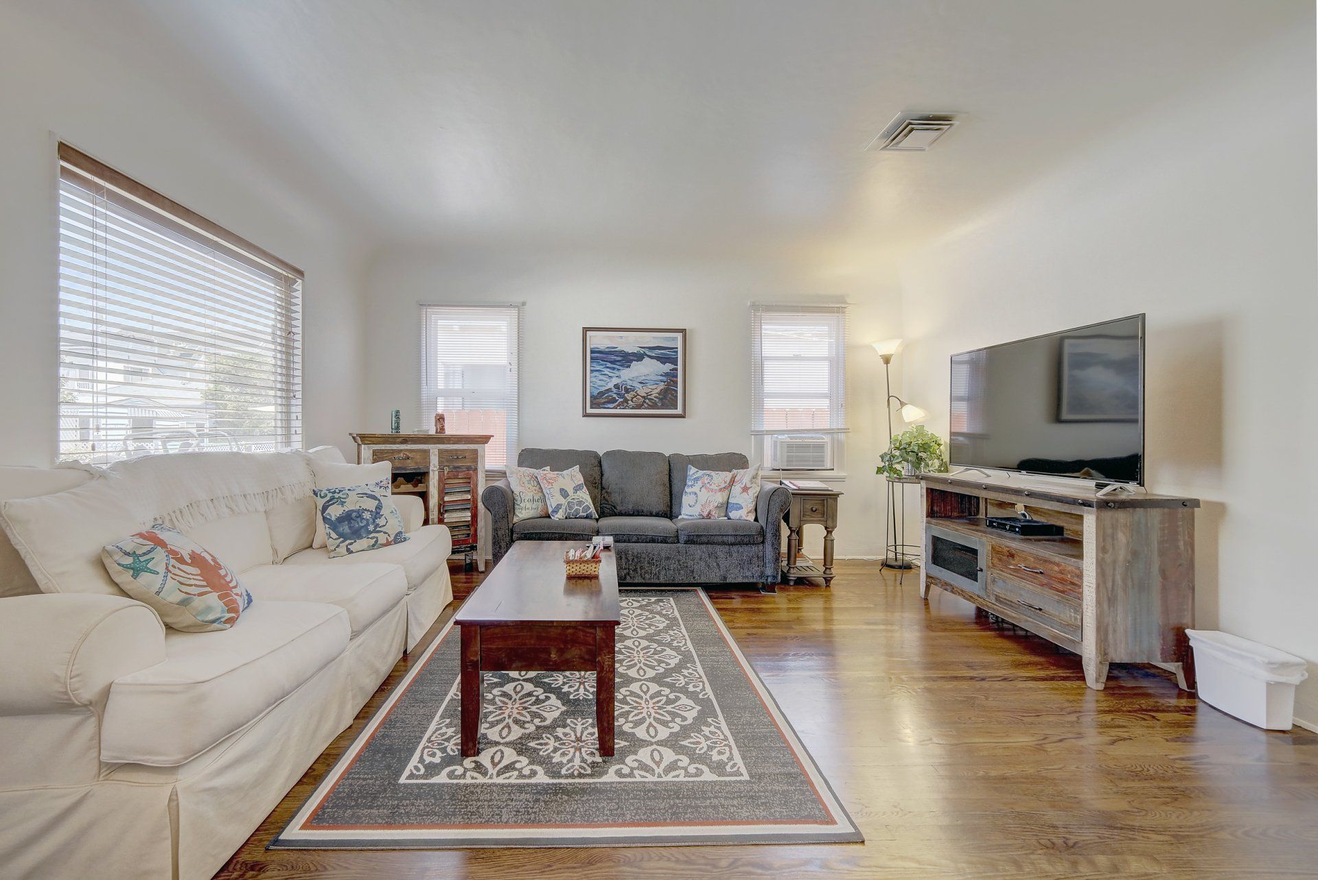 A living room with two couches , a coffee table , and a flat screen tv.