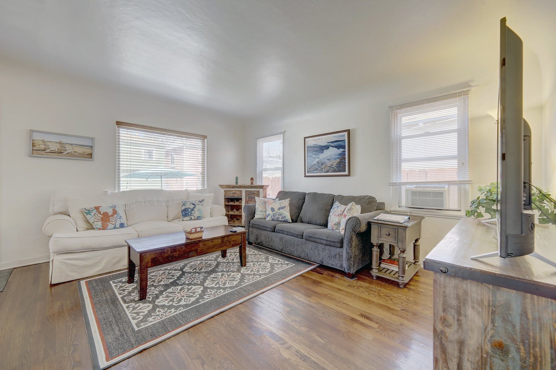 A living room with a couch , coffee table , and television.