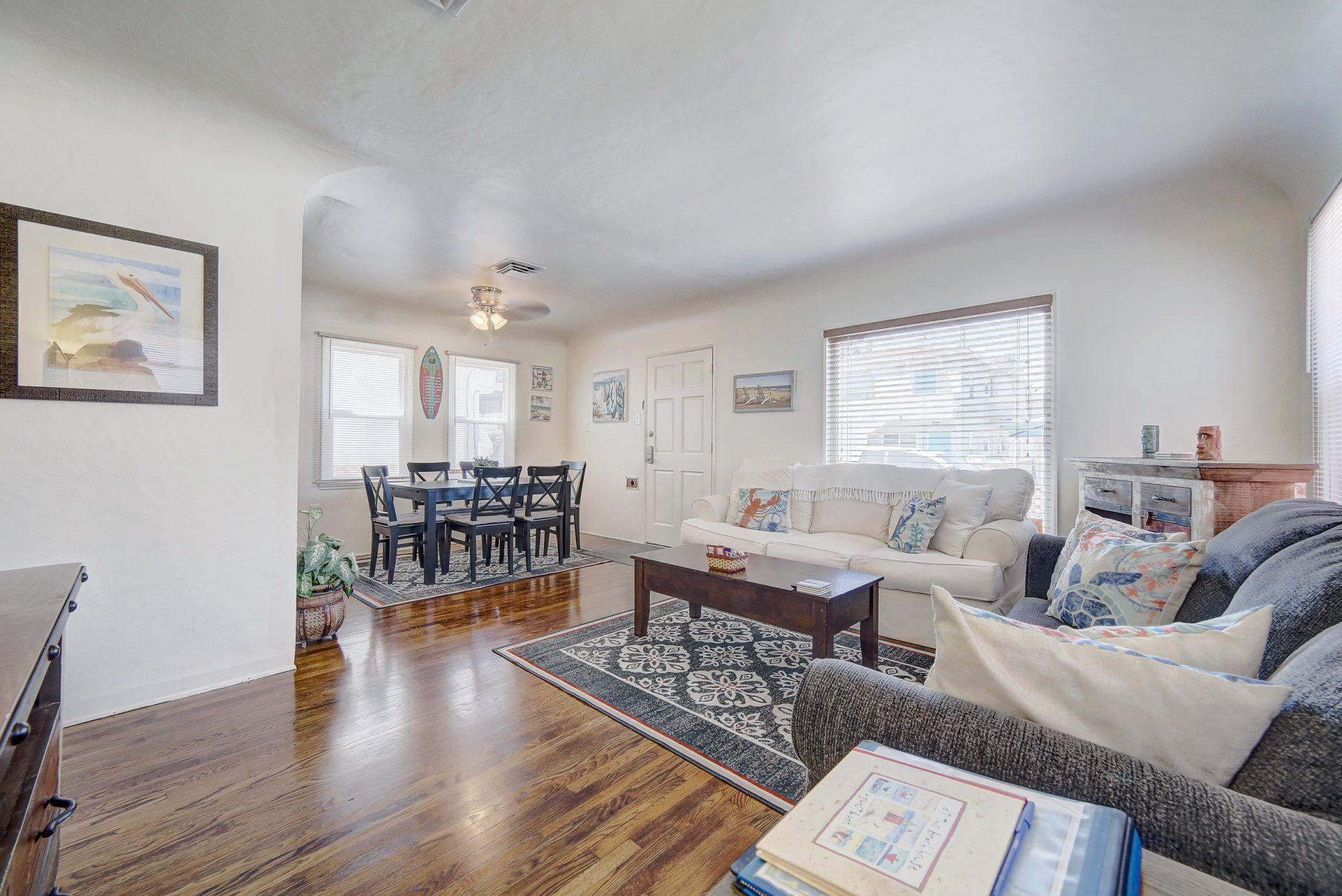 A living room with a couch , chair , coffee table and dining table.