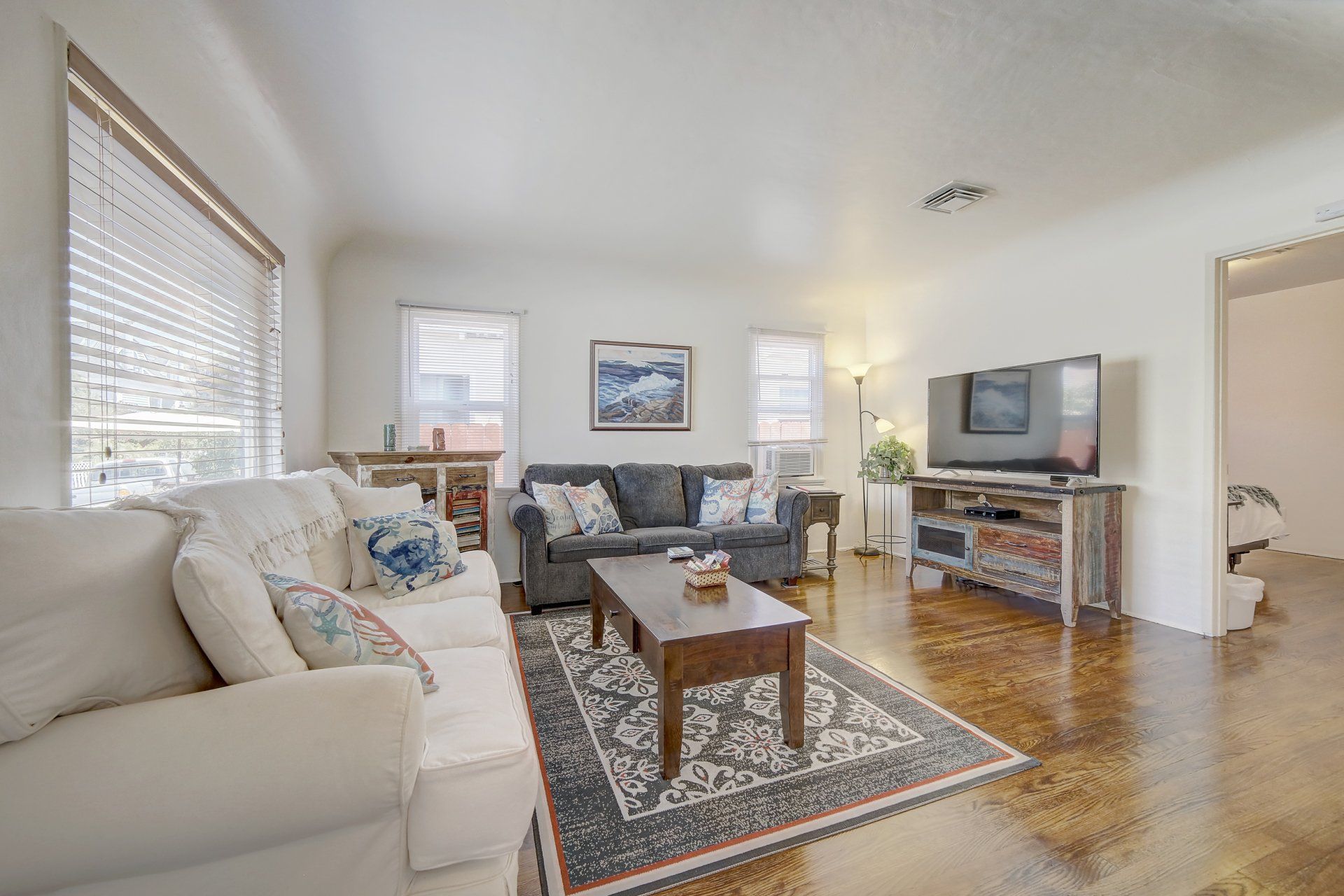 A living room with a couch , coffee table , and television.