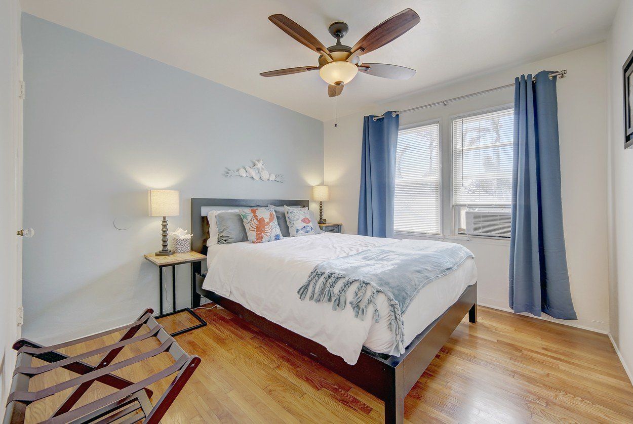 a bedroom with a bed and a ceiling fan