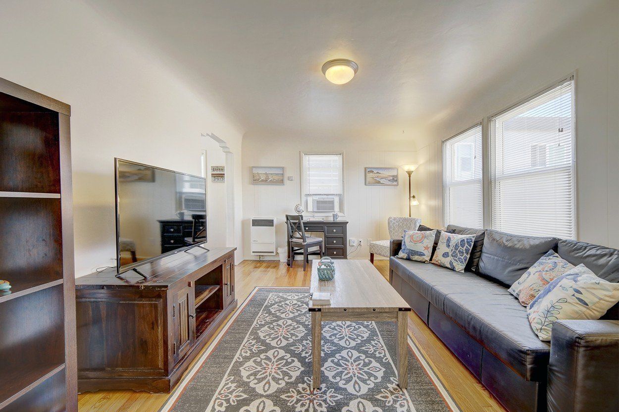 A living room with a couch , coffee table , and television.