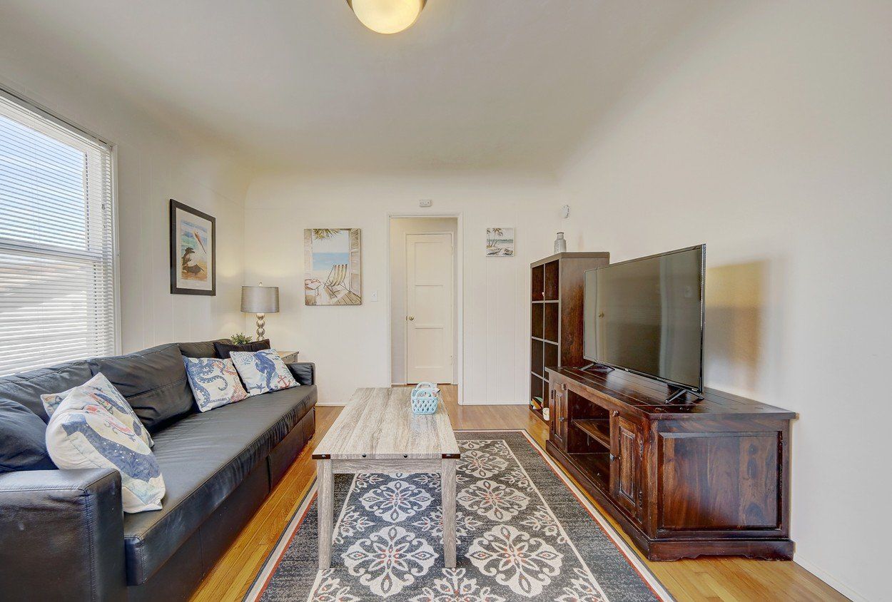 A living room with a couch , coffee table , and television.