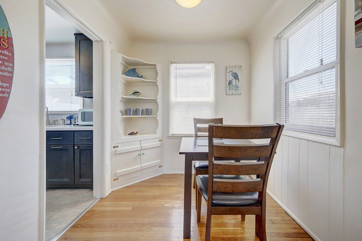 A dining room with a table and chairs and a window.