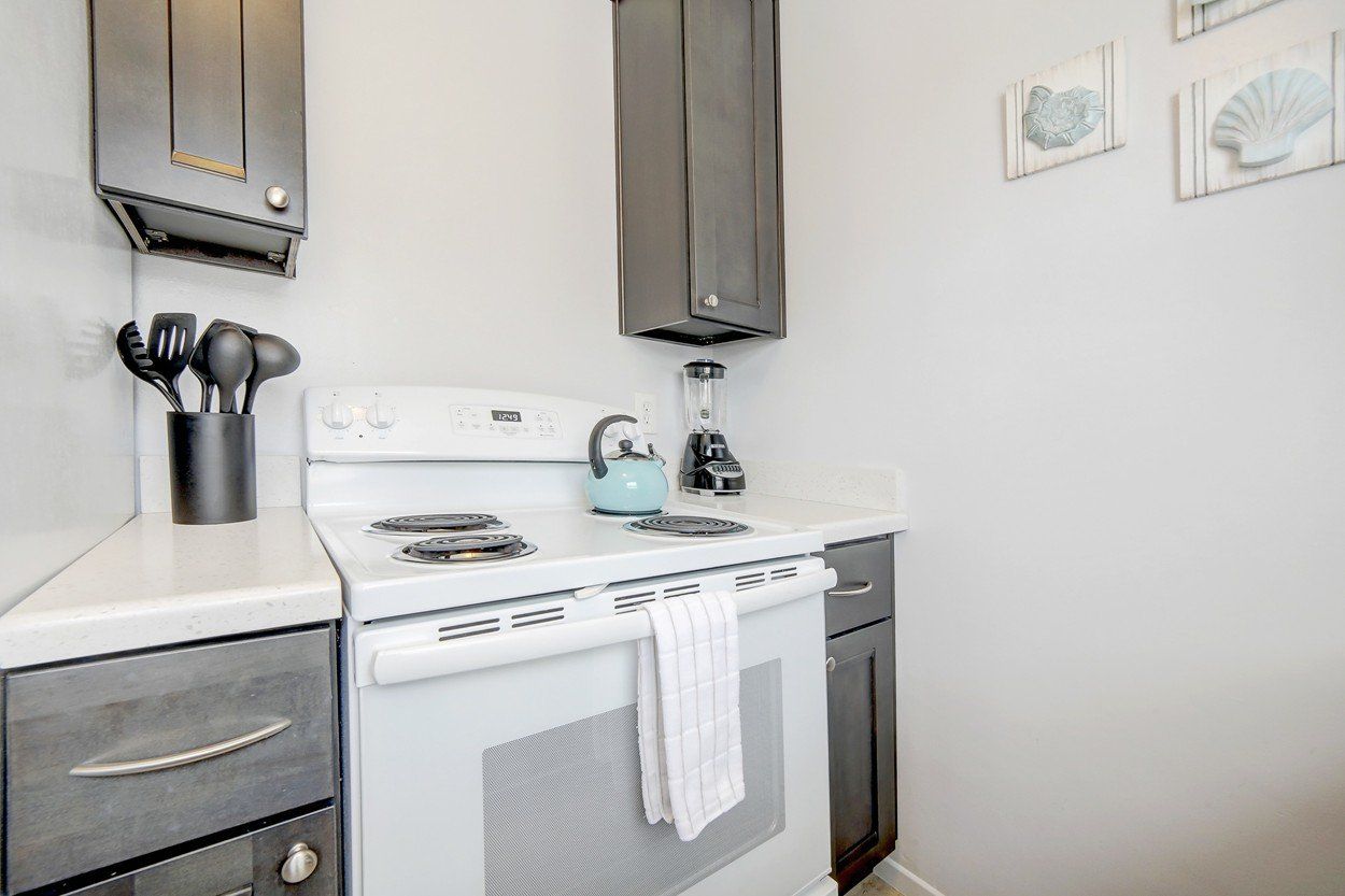 a kitchen with a stove , oven , and cabinets .