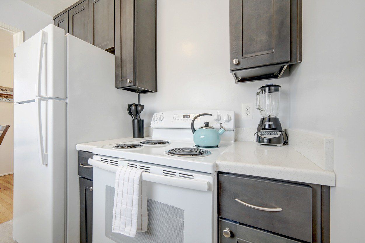 a kitchen with a stove , refrigerator , and blender .