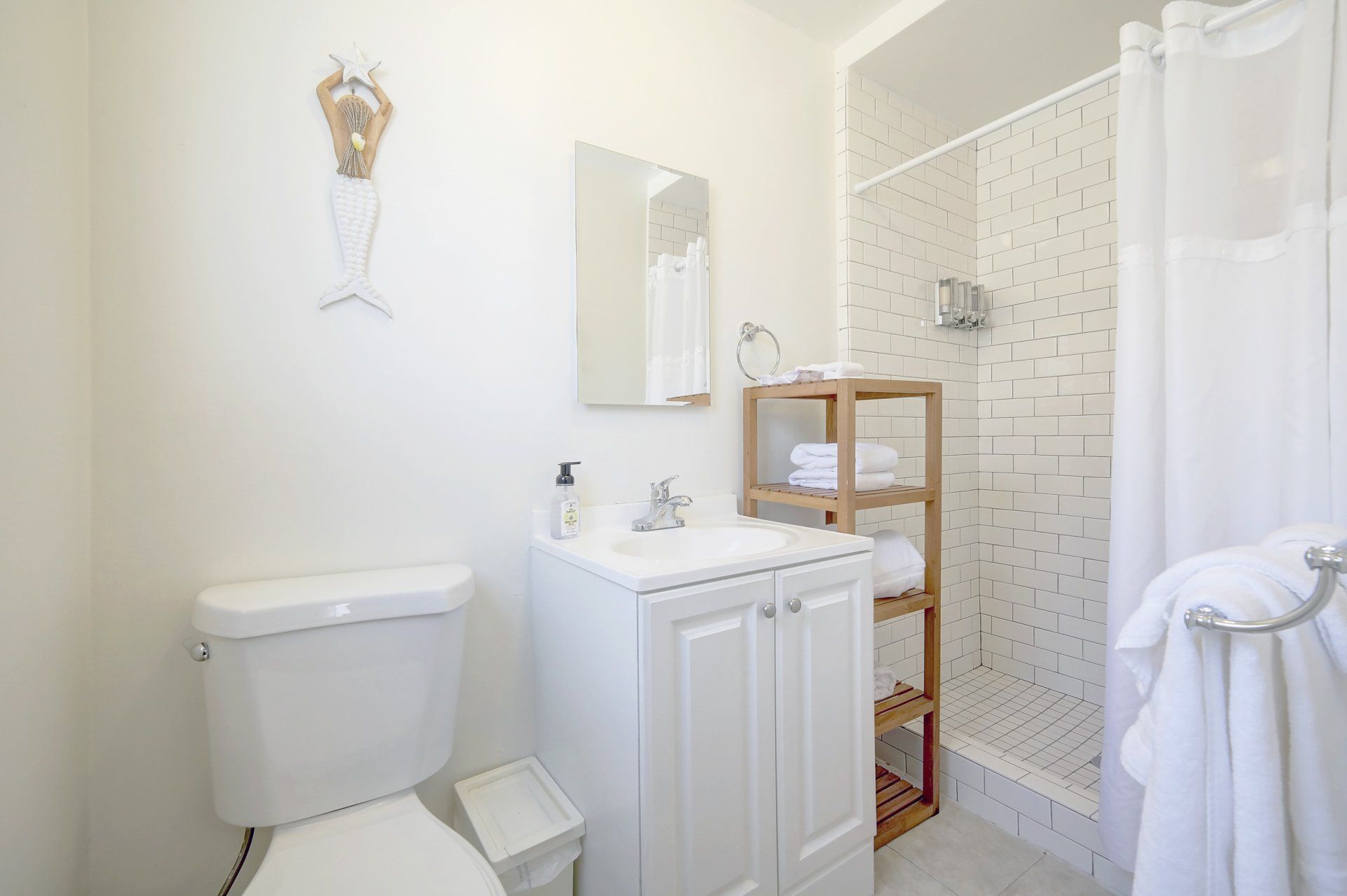 a bathroom with a toilet , sink , mirror and shower .