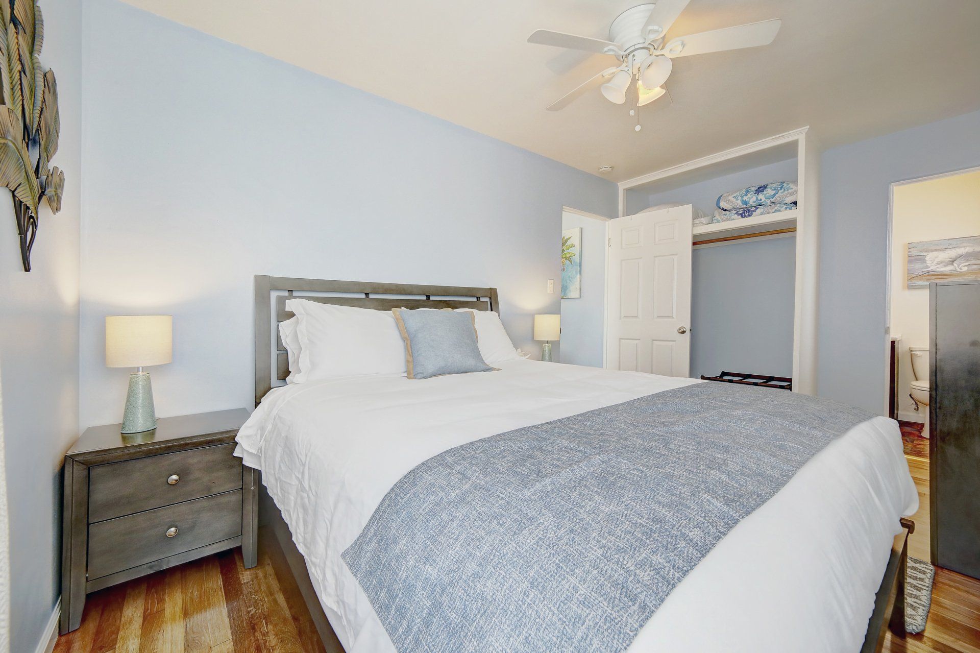 A bedroom with a king size bed and a ceiling fan.