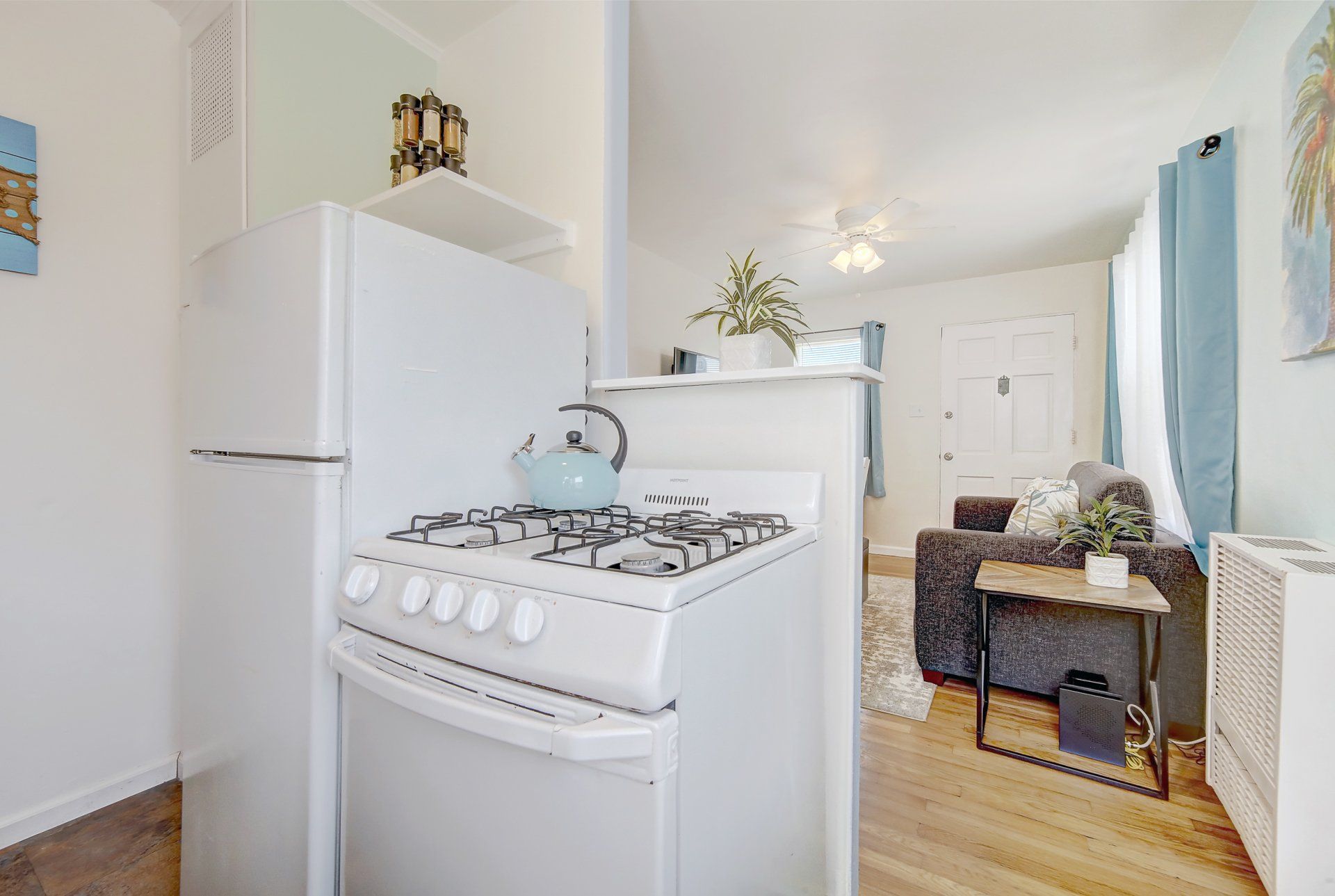 a kitchen with a stove , refrigerator , and a living room .