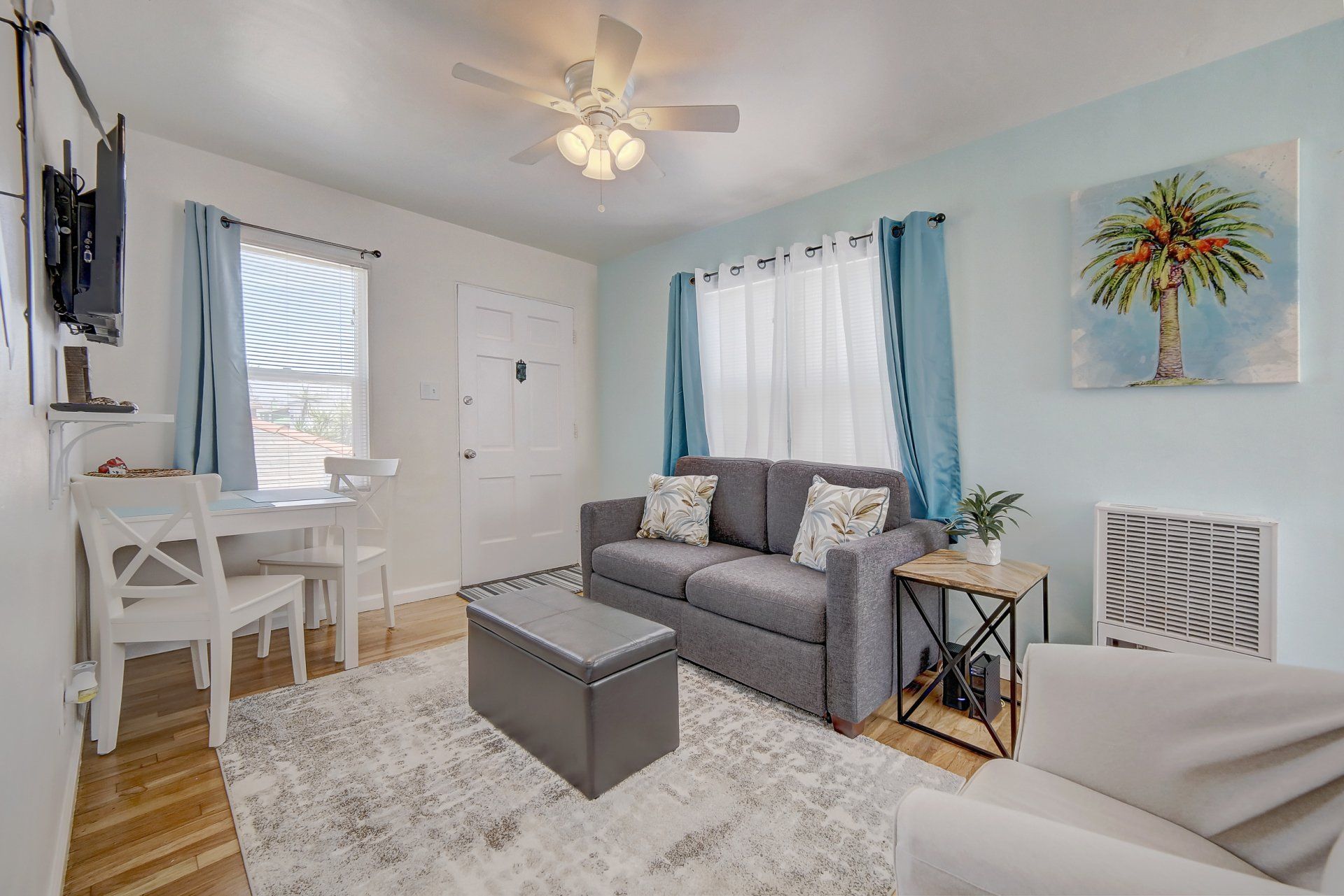 a living room with a couch , chair , table and television .