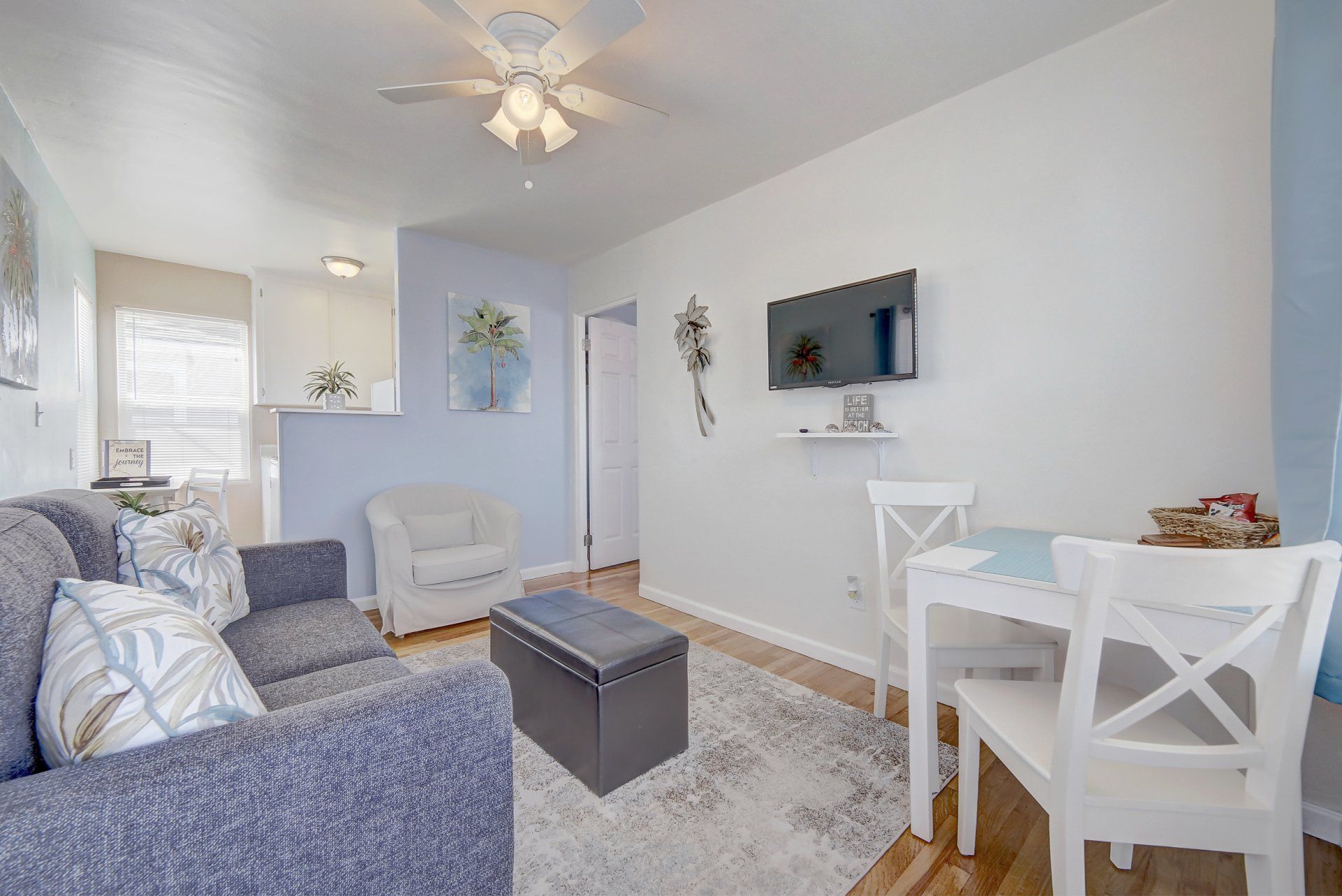 a living room with a couch , chair , table and television .