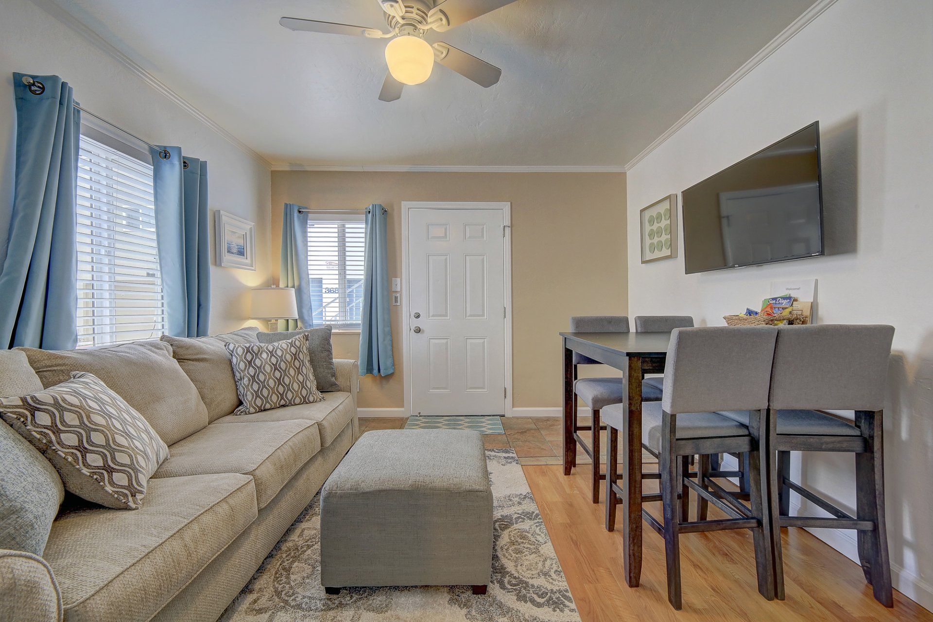 a living room with a couch , table , chairs and a flat screen tv .