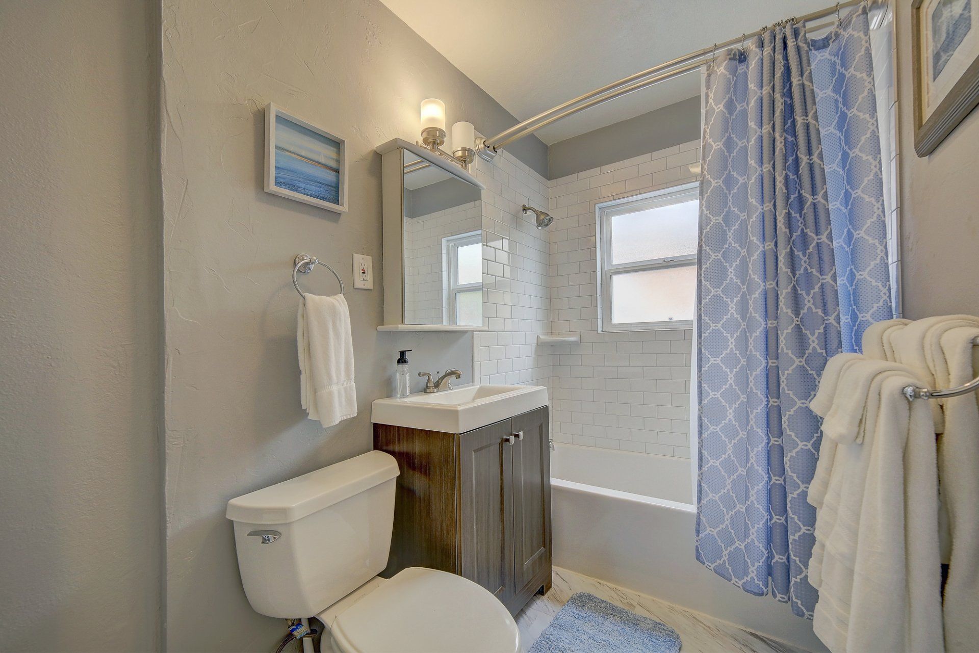 A bathroom with a toilet , sink , and shower curtain.