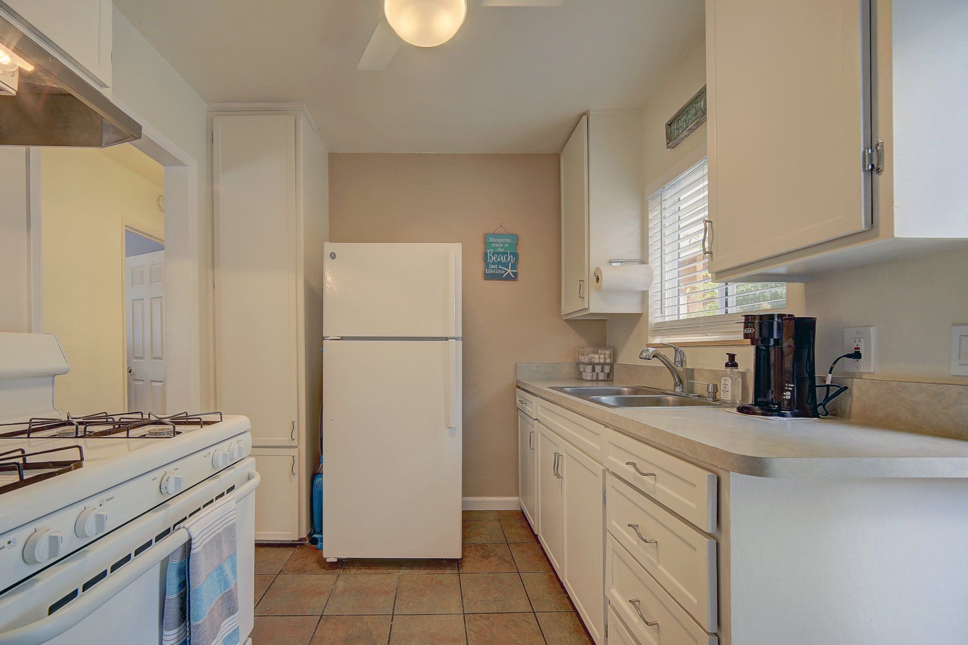 A kitchen with white cabinets and a white refrigerator