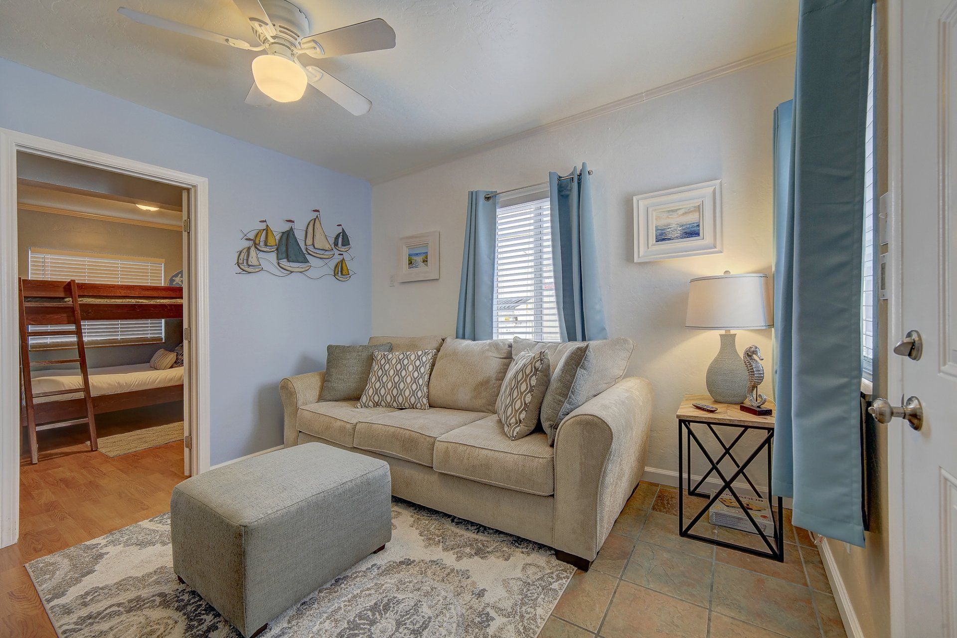 a living room with a couch , ottoman , and bunk beds .