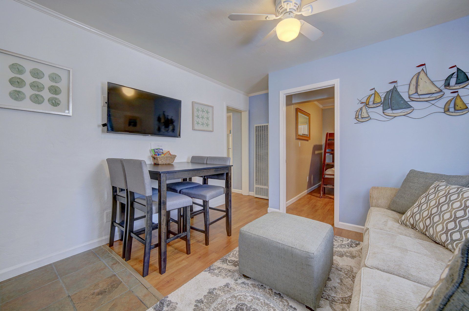 a living room with a couch , table , chairs and a flat screen tv .