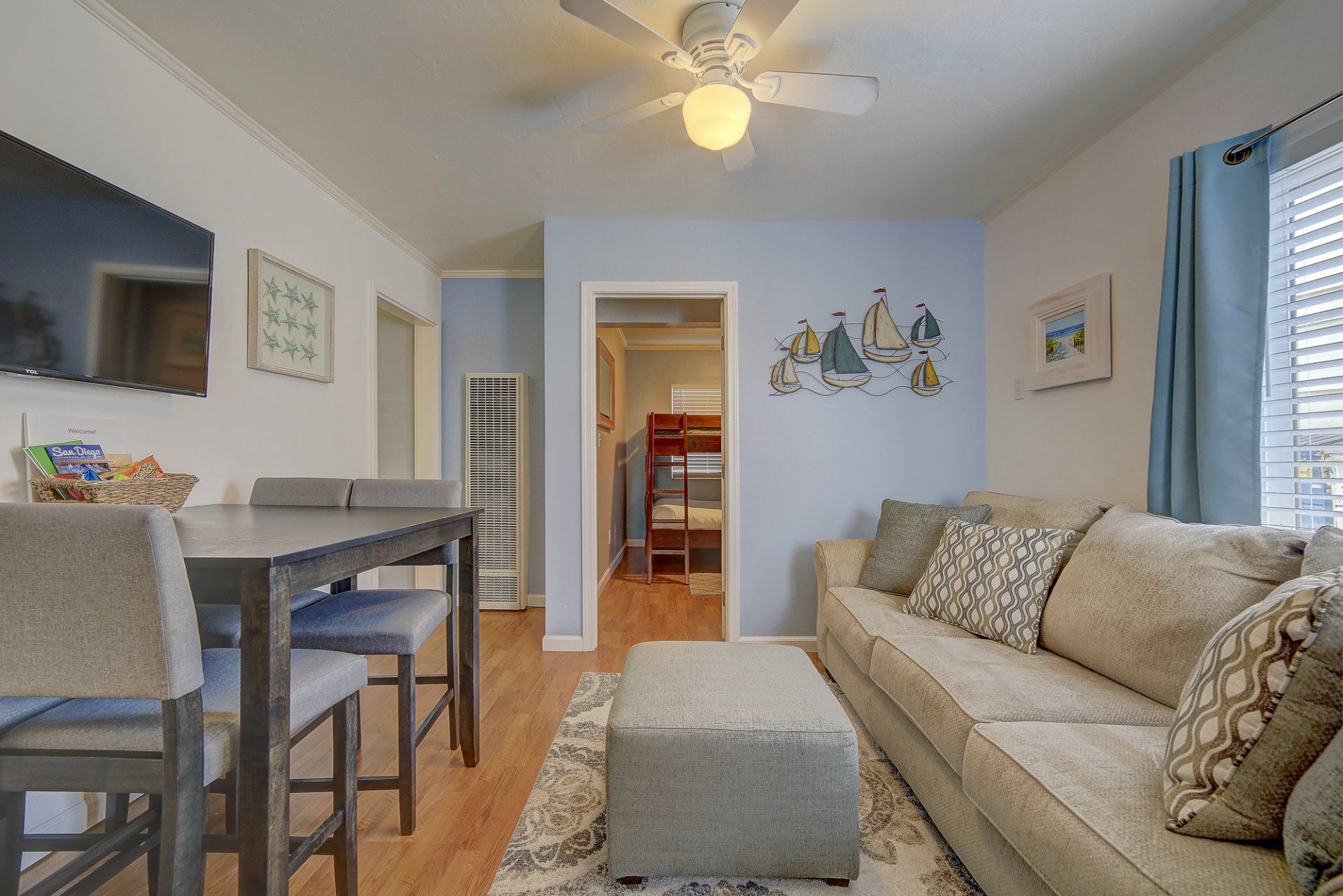 a living room with a couch , table and chairs and a ceiling fan .