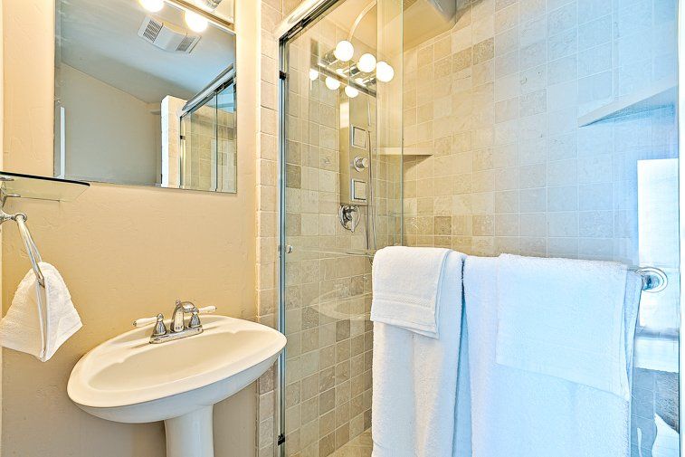 A bathroom with a sink , mirror , and shower.