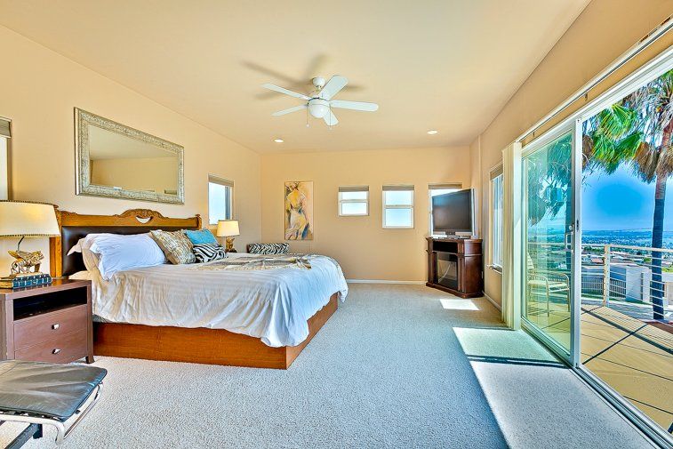 A bedroom with a large bed and a sliding glass door