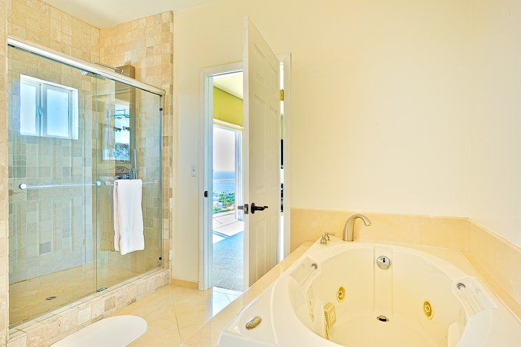 A bathroom with a jacuzzi tub and a walk in shower.