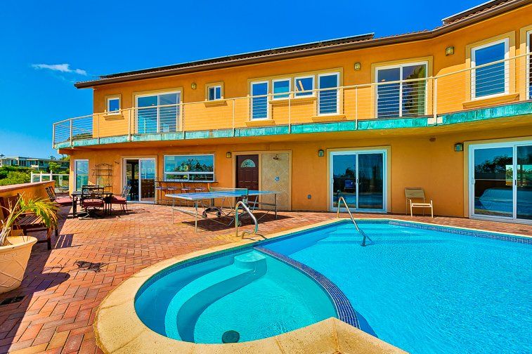 a large house with a large swimming pool in front of it