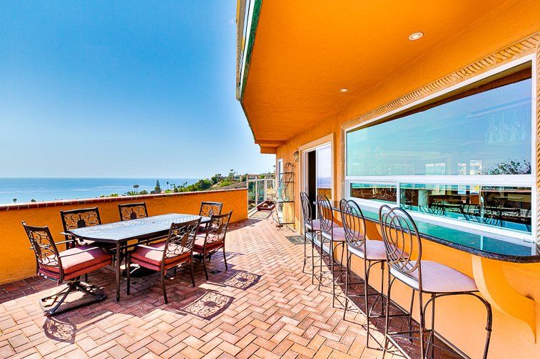 a patio with a table and chairs overlooking the ocean .