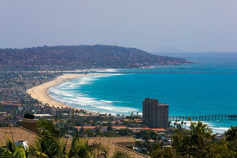 A view of a beach with a city in the background