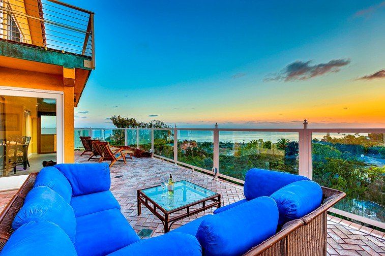 there is a couch on the balcony with a view of the ocean .