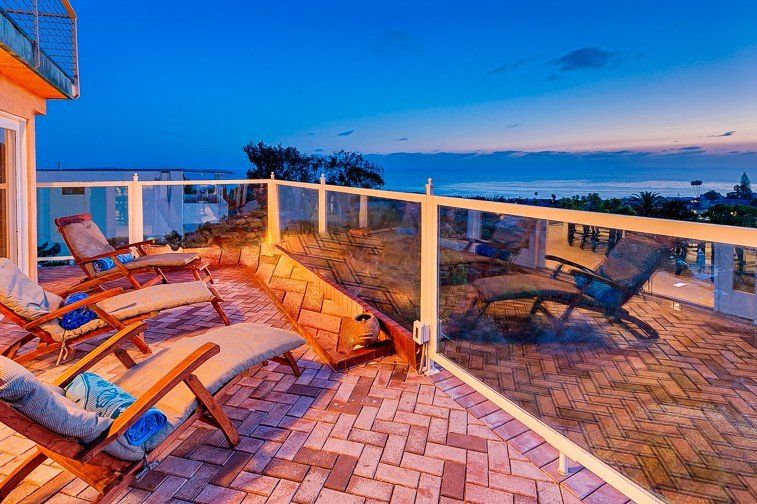 there are a lot of chairs on the balcony with a view of the ocean .