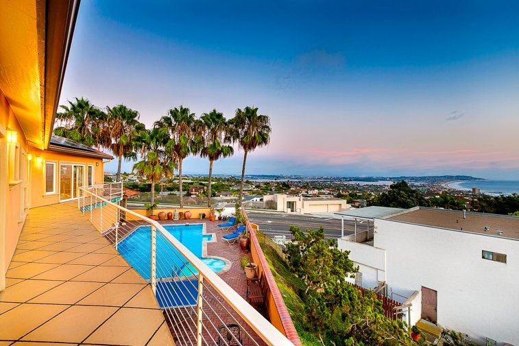 there is a large swimming pool on the balcony of a house .