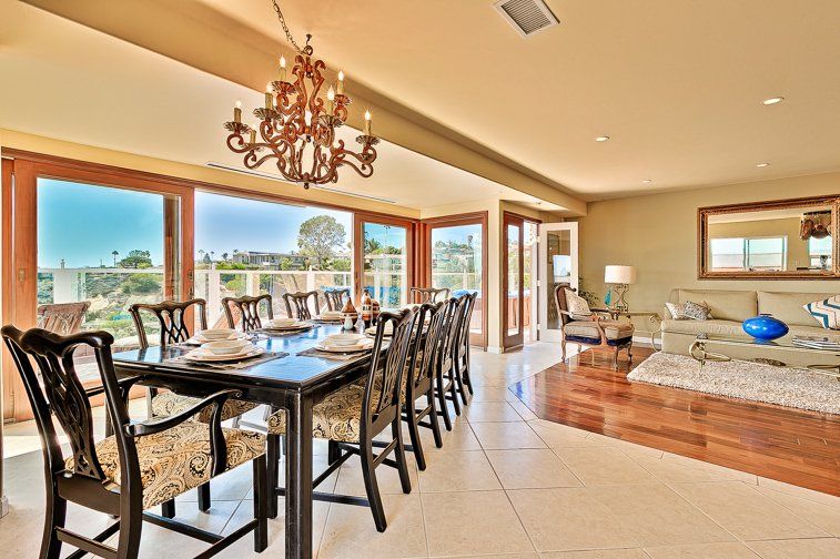 a dining room with a long table and chairs and a chandelier .