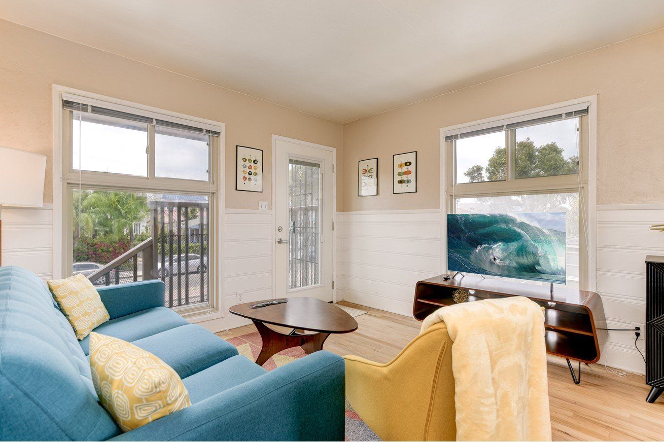 A living room with a blue couch and a yellow couch.