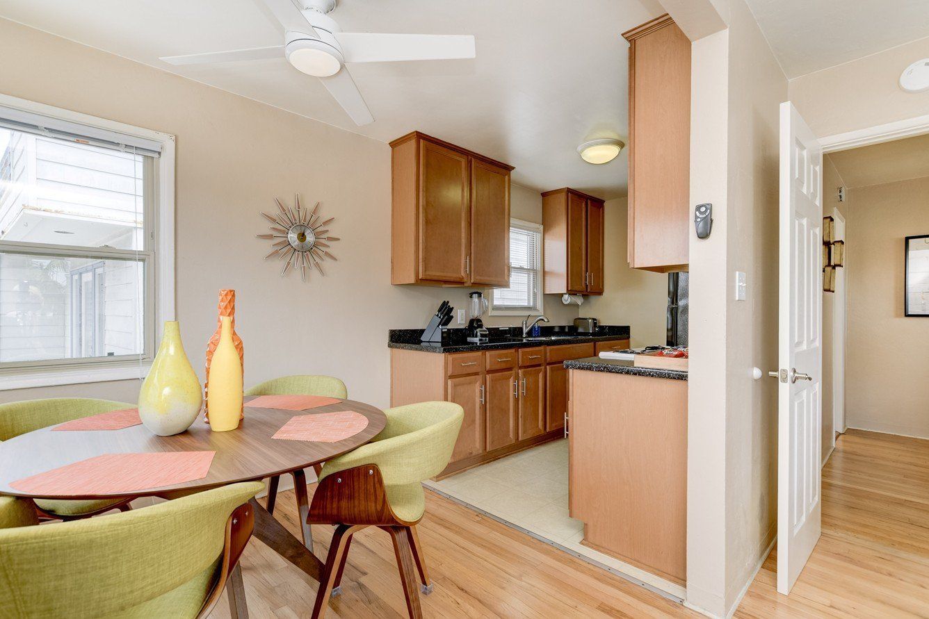 a kitchen with a table and chairs and a ceiling fan .