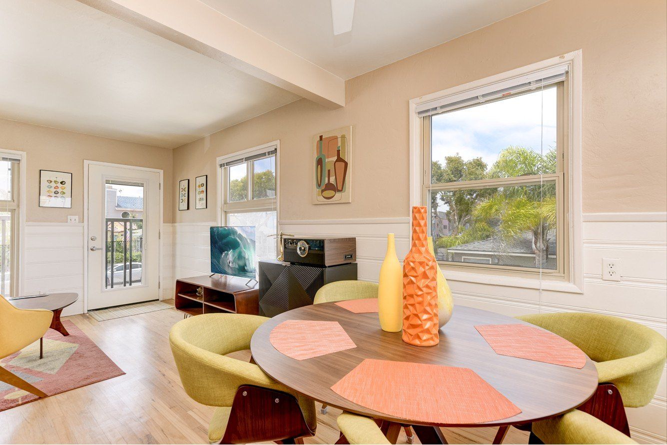 a living room with a table and chairs and a window .