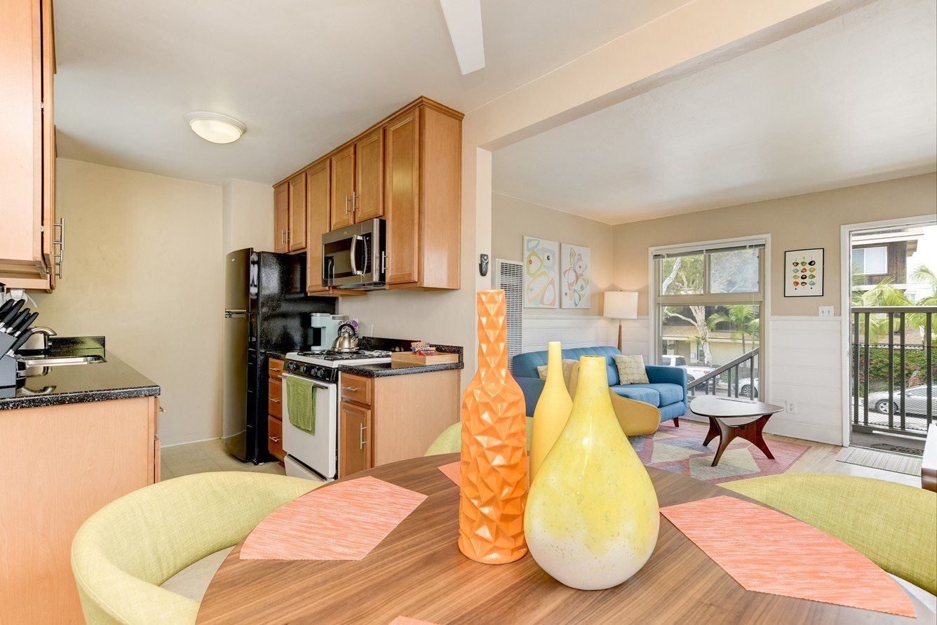 a kitchen with a table and chairs and vases on it