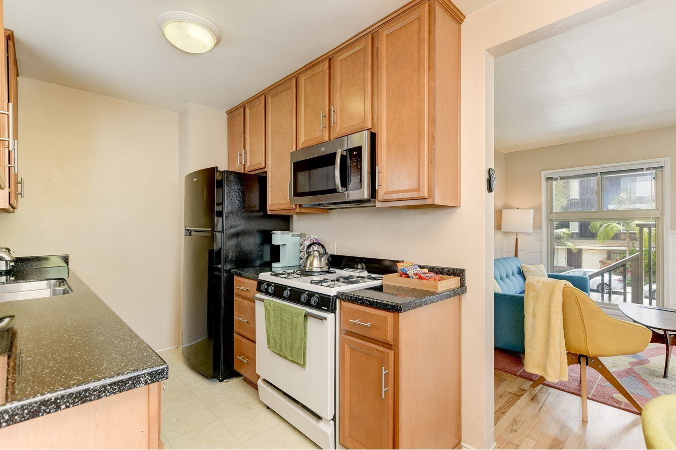 a kitchen with a stove , refrigerator , microwave and sink .