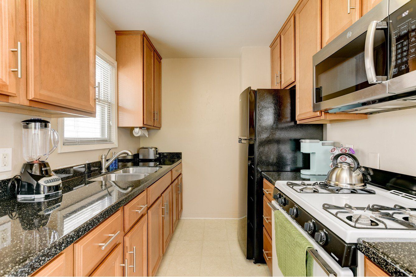 a kitchen with a stove , refrigerator , microwave and sink .