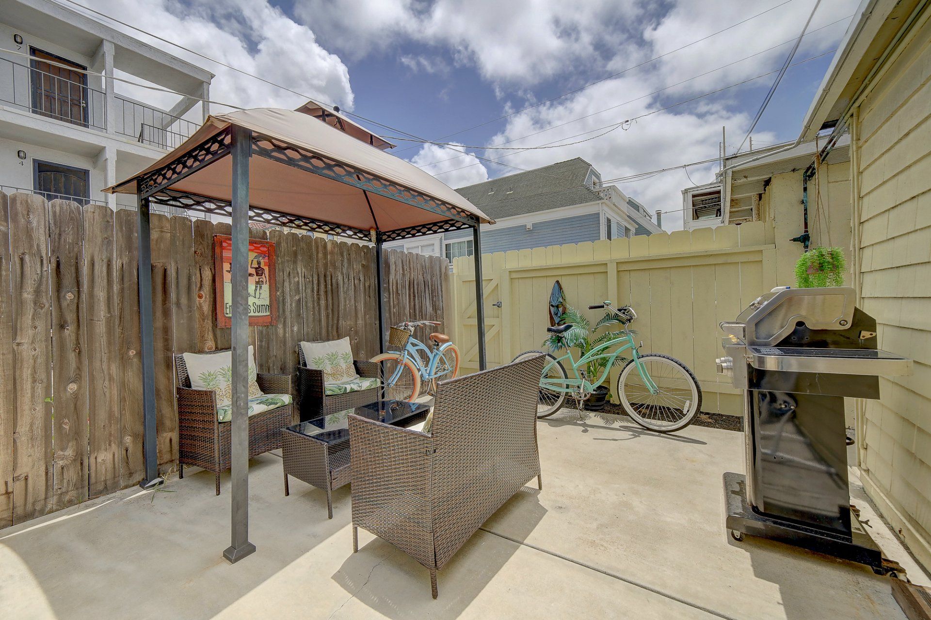 a patio with a gazebo , bicycles , and a grill .