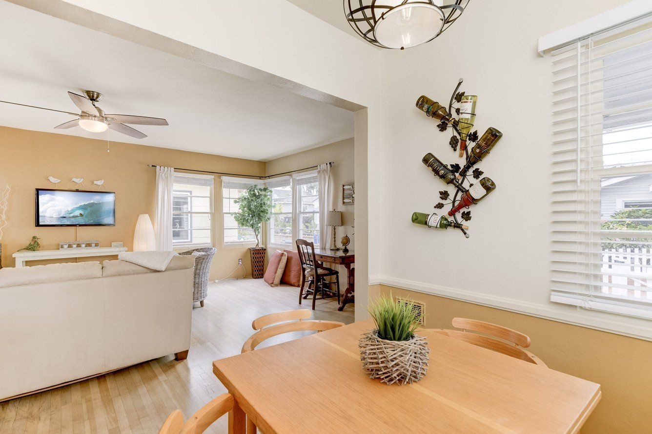 A living room with a table and chairs and a wine rack on the wall.