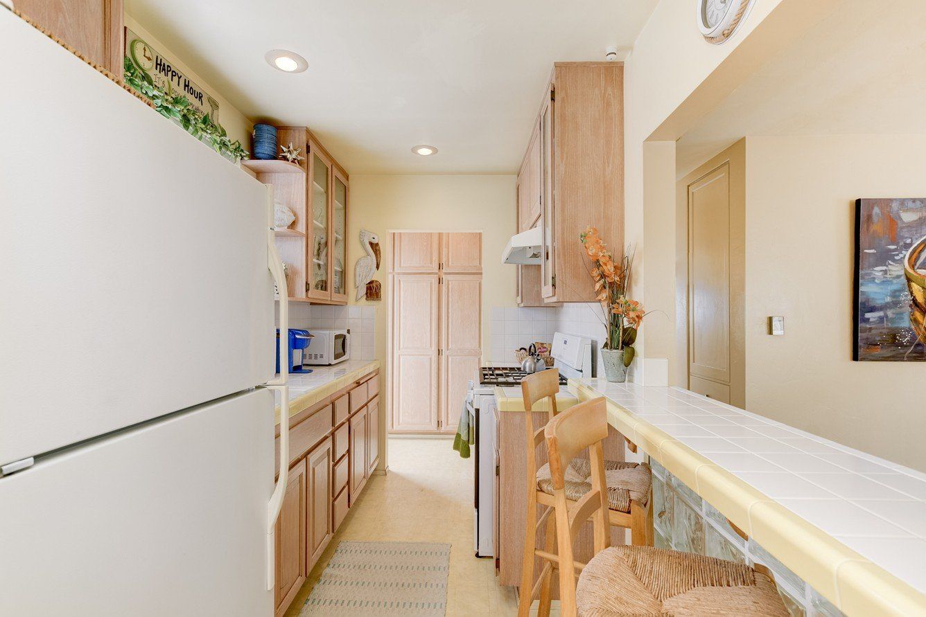 a kitchen with a white refrigerator and wooden cabinets