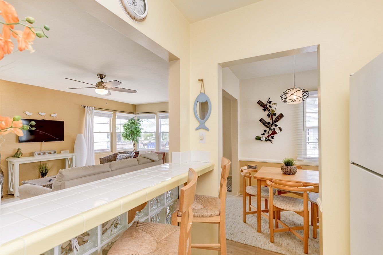 a kitchen with a table and chairs and a clock on the wall .