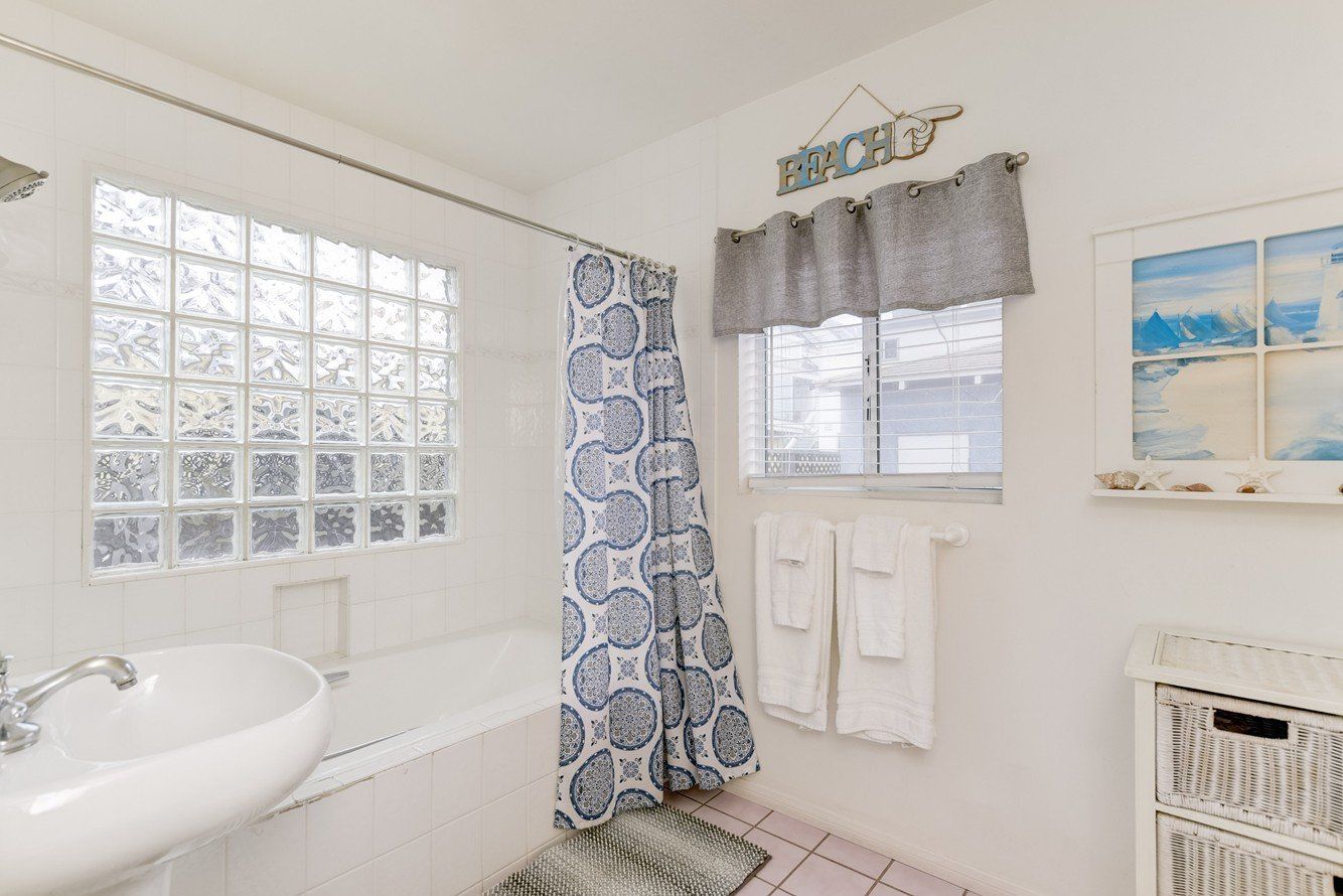 a bathroom with a bathtub , sink , and shower curtain .