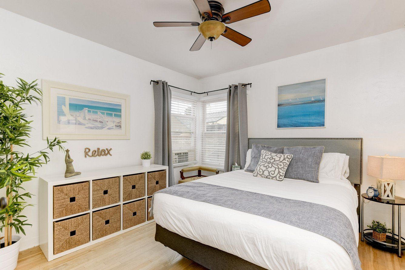 A bedroom with a large bed and a ceiling fan.