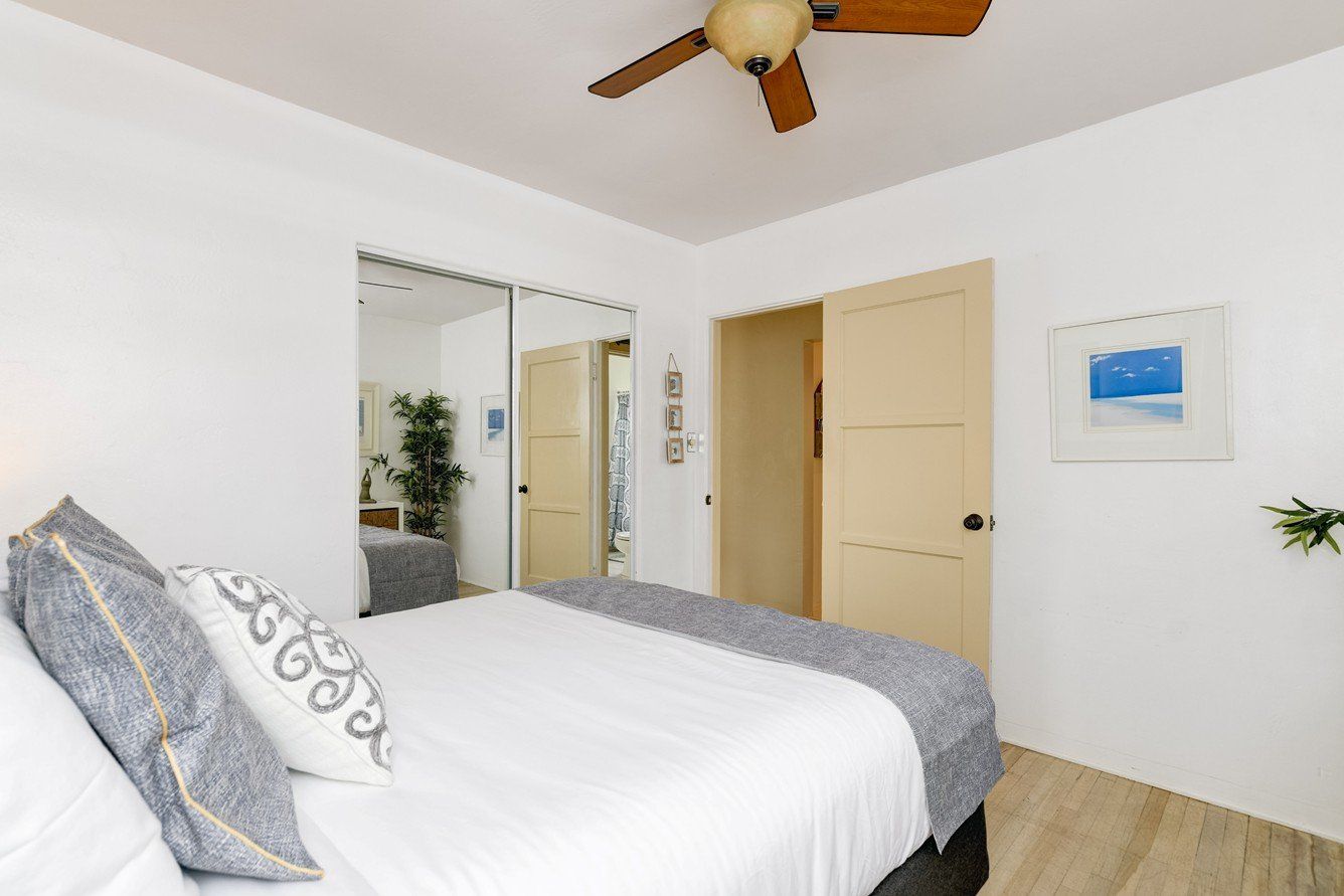 A bedroom with a large bed and a ceiling fan.