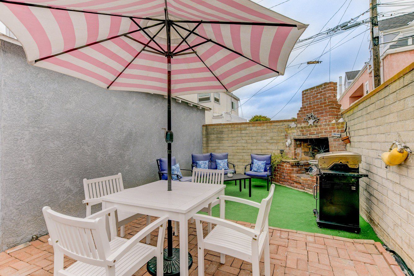 a patio with a table and chairs under an umbrella