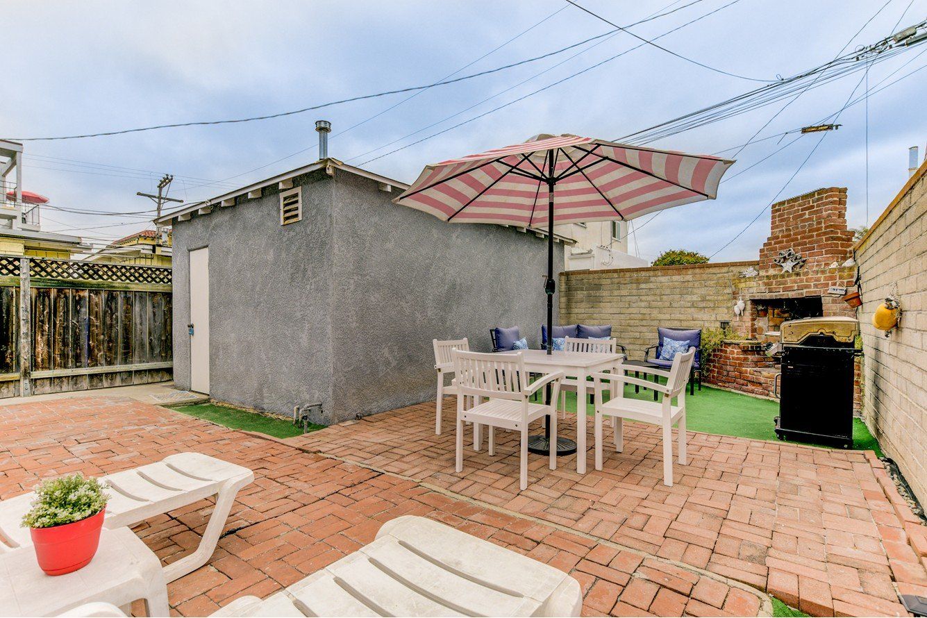 a patio with a table and chairs and an umbrella .