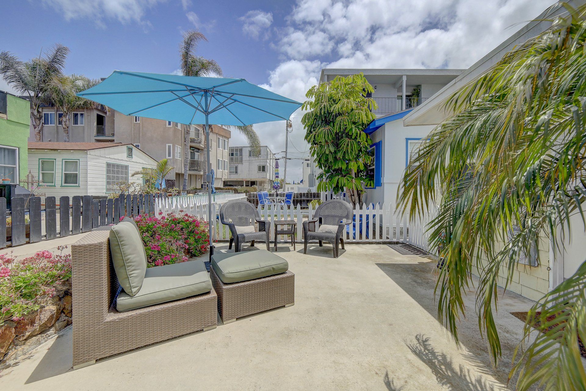 a patio with a table and chairs and a blue umbrella .