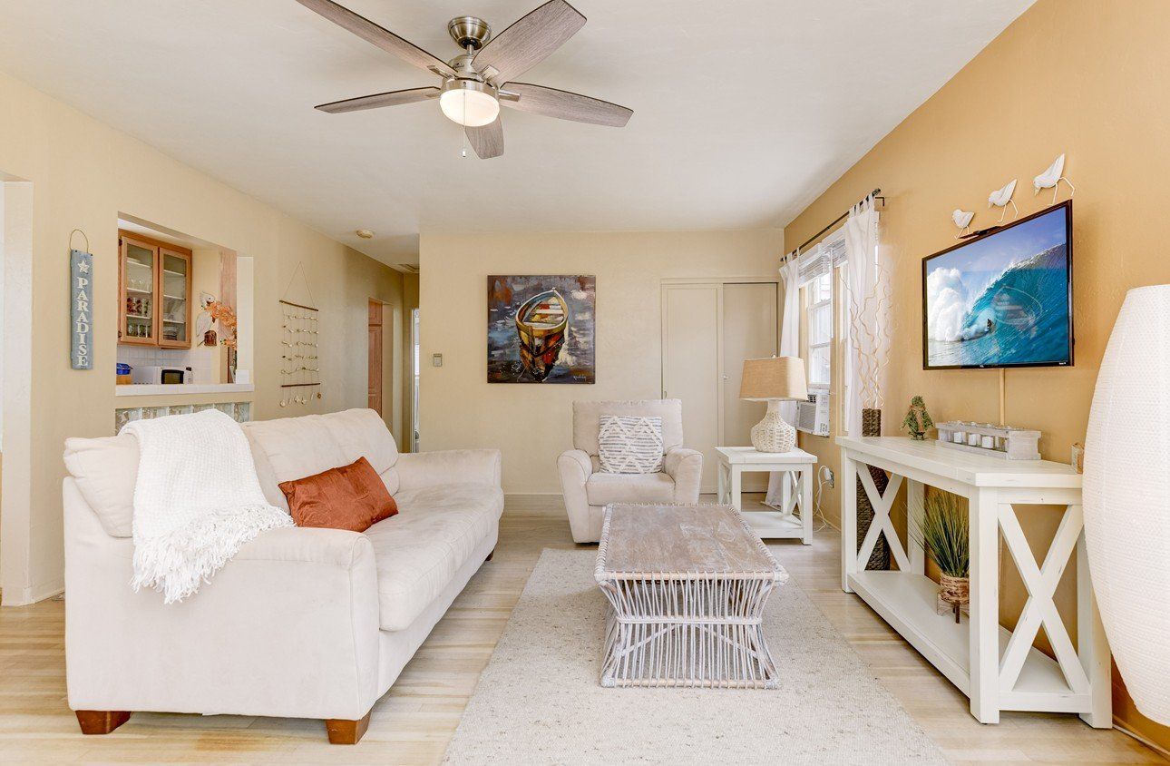 a living room with a ceiling fan and a flat screen tv