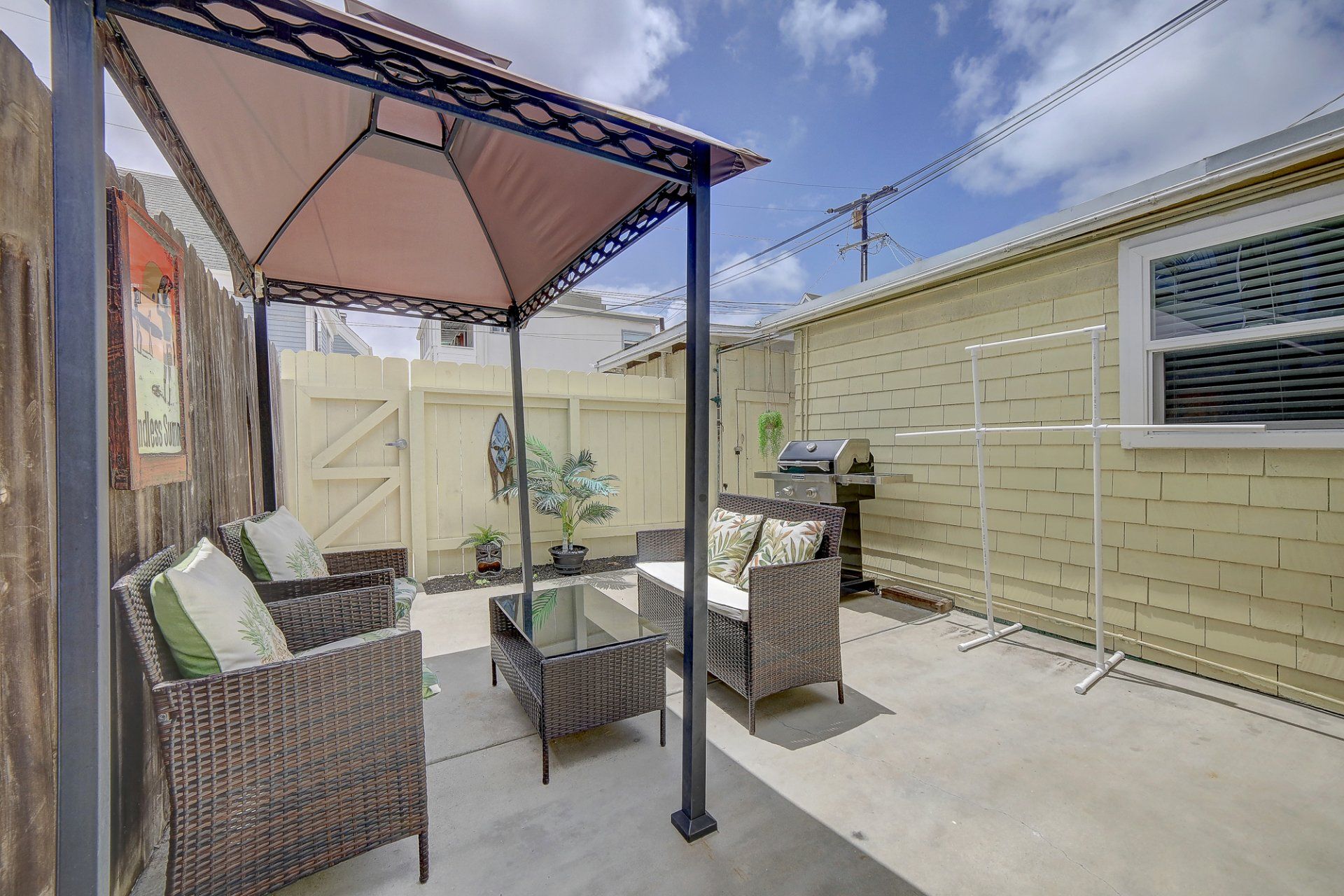 a patio with wicker furniture and a gazebo in front of a house .